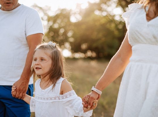 A man and a woman holding hands with a little girl